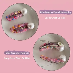 Handmade pink wool felt hair clips for girls featuring colorful pom-poms and white pearls