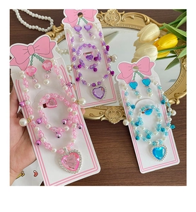 Close-up of pink heart gemstone necklace set with beaded bracelet and earrings for girls