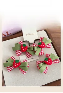 Détail d'élastiques fraise à carreaux rouges avec des accents crochetés sur plateau bois