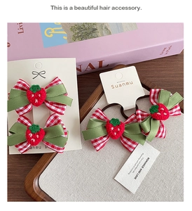Détail de barrettes à fraises à carreaux rouges et élastique avec accents tricotés