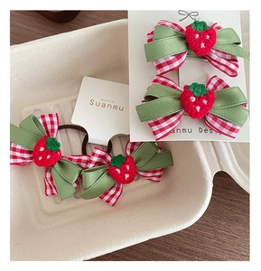 Détail de pinces à cheveux à carreaux rouges avec fraise au crochet sur carte