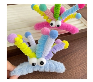 Détail de pinces à cheveux en peluche colorées avec de grands yeux et des pieds torsadés