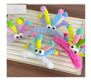 Détail de pinces à cheveux en peluche colorée avec grands yeux et antennes rigolotes
