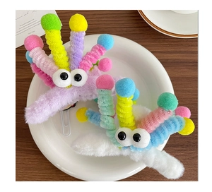 Détail de pinces à cheveux en peluche avec yeux de dessin animé et pompons colorés