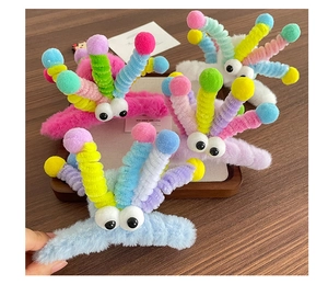 Détail de quatre pinces à cheveux en peluche avec des yeux de dessin animé et tentacules