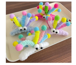 Détail de pinces à cheveux en peluche avec de grands yeux en couleurs pastel
