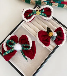 Détail de trois nœuds de cheveux de Noël en velours rouge avec bordure en fourrure blanche.