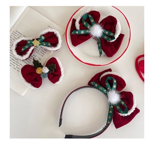 Détail d'accessoires de Noël avec nœuds en velours rouge et pompons blancs doux