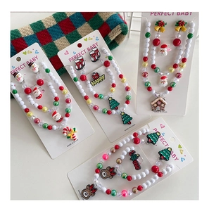 Detailed view of Christmas jewelry set for kids featuring Santa and reindeer charms