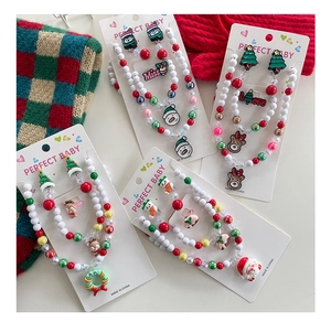 Macro shot of children's Christmas jewelry set with resin Santa and reindeer motifs