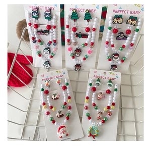 Close-up of diverse kids Christmas jewelry sets with Santa and reindeer beads in a basket