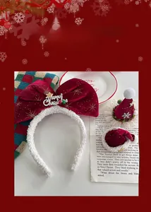 Détail d'un serre-tête de Noël en velours rouge avec grand nœud pailleté et mini chapeaux