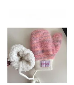 Detail view of pink knit baby gloves with warm white fleece lining and neck strap
