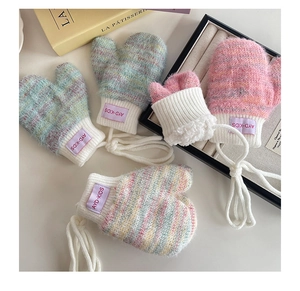 Detail of warm knitted baby mittens with thick fleece lining and neck string