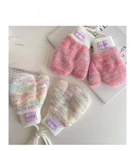 Detail of pink and white plush knit baby mittens with ribbed cuffs and neck lanyard