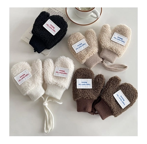 Flat lay of four plush fleece baby mittens with neck strings in black, beige, white, and brown