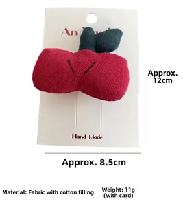 Macro shot of handmade cherry-shaped cotton padded hair clip on a white display card