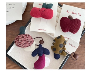Detailed macro view of handmade fabric fruit hair clips and floral scrunchie set