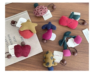 Detail of assorted handmade plush hair ties with cute stars, mushrooms, and cherry shapes