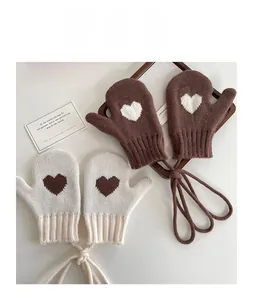 Detail of knitted mittens with heart pattern, ribbed cuffs and anti-lost neck string