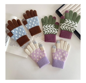 Detailed close-up of knit gloves showing three color patterns and touchscreen tips