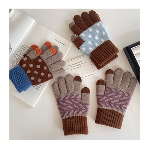 Detailed close-up of knitted winter gloves with polka dots and geometric patterns