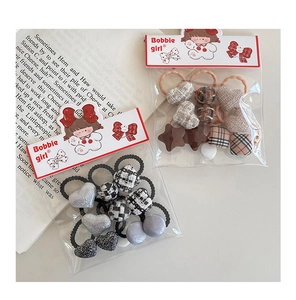 Détail de chouchous pour filles avec motifs à carreaux et cœurs en tweed
