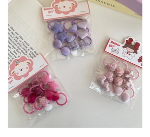 Détail d'élastiques à cheveux pour enfants avec motifs cœurs, étoiles et tissu à carreaux