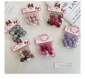 Vue macro à plat de chouchous élastiques colorés avec motifs cœur et boules à carreaux