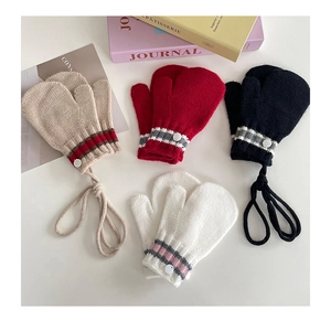 Flat lay of colorful knit children's mittens with neck strings and stripe details