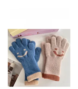 Close-up of knit winter gloves featuring cute smiley faces and colorful ribbed cuffs