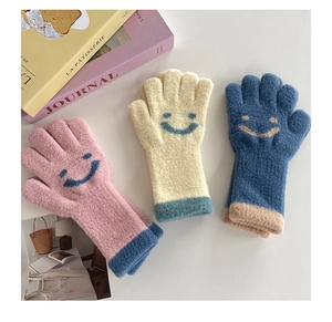 Close-up of knitted gloves featuring cute smiley faces and windproof ribbed cuffs