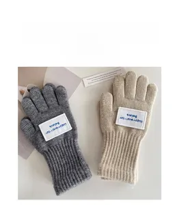 Detailaufnahme dicker Strickhandschuhe für Kinder mit Believe Happy Everyday Aufnäher