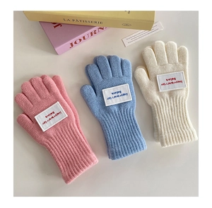 Detail der Strickstruktur von rosa und blauen fingerlosen Winterhandschuhen für Kinder