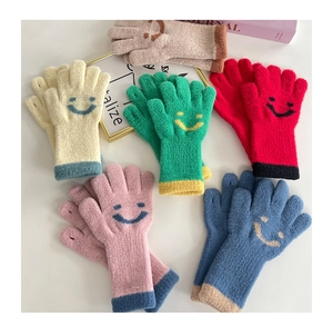 Detail of colorful knitted gloves featuring smiling face patterns and ribbed cuffs