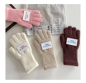 Detailaufnahme von Strickhandschuhen in Rosa, Beige und Braun mit elastischen Rippbündchen