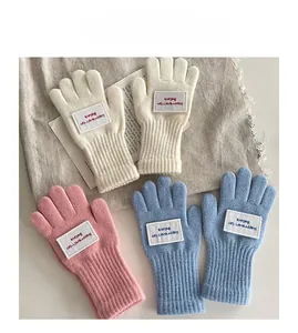 Detail von warmen Strickhandschuhen für Kinder in Creme Rosa und Hellblau Farben