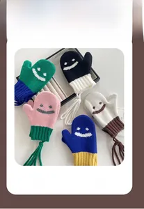 Dettaglio di guanti in maglia colorati per bambini con sorrisi e cordini anti-smarrimento