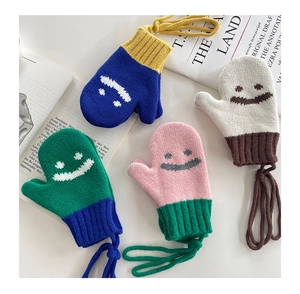 Dettaglio di muffole in maglia colorate per bambini con faccine e cordini al collo