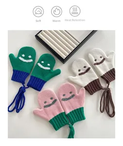 Guanti in maglia per bambini con faccine sorridenti e cordino anti-smarrimento