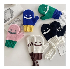 Dettaglio di muffole in maglia colorate con faccina sorridente e cordino anti-smarrimento