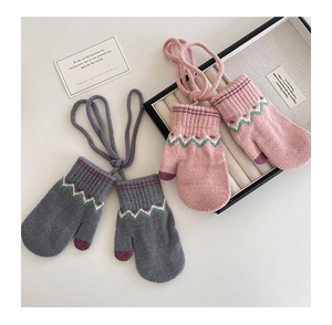 Detail of soft winter knit gloves for kids with wavy cuffs and neck string in pink and gray