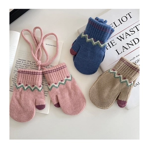 Detailed view of knitted winter gloves for children with wavy jacquard and neck cord