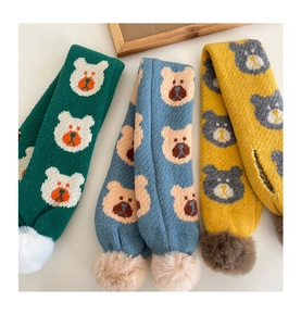Vue détaillée d'écharpes tricotées avec motifs d'ours et pompons en peluche décoratifs