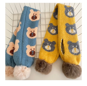 Détail d'écharpes en tricot avec motifs d'ours et pompons doux pour enfants