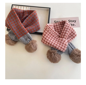 Detailansicht der karierten Strickschals mit Kontrast-Pompons und grauen Akzenten