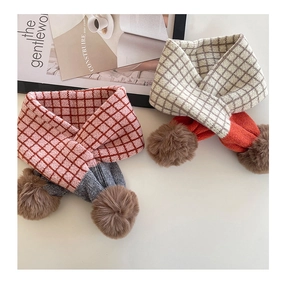Detailansicht der gestrickten Karoschals mit weichen Pompons für Kinder im Winter