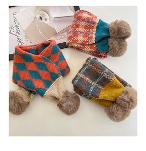 Detailansicht gestrickter Karo-Schals mit weichen Pelz-Pompons für Kinder