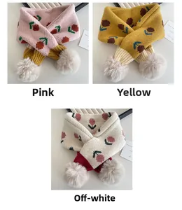 Dettaglio di sciarpe in maglia per bambini con motivi floreali e morbidi pompon di peluche