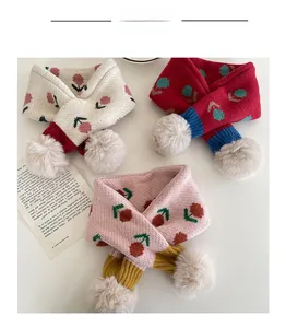 Dettagli di sciarpe in maglia per neonati con motivi a ciliegia e pompon bianchi in tre colori
